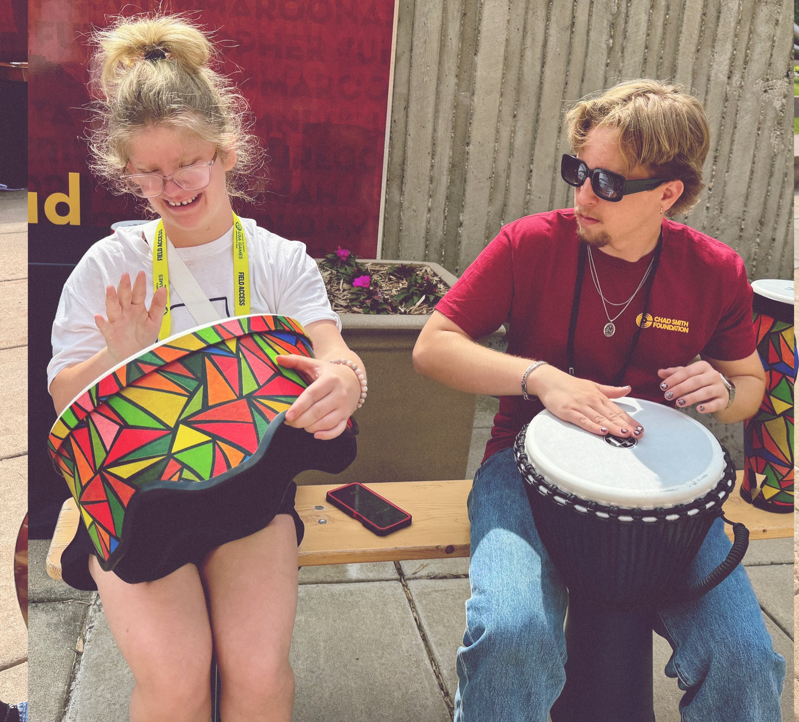 Athlete playing a hand drum with a volunteer musician