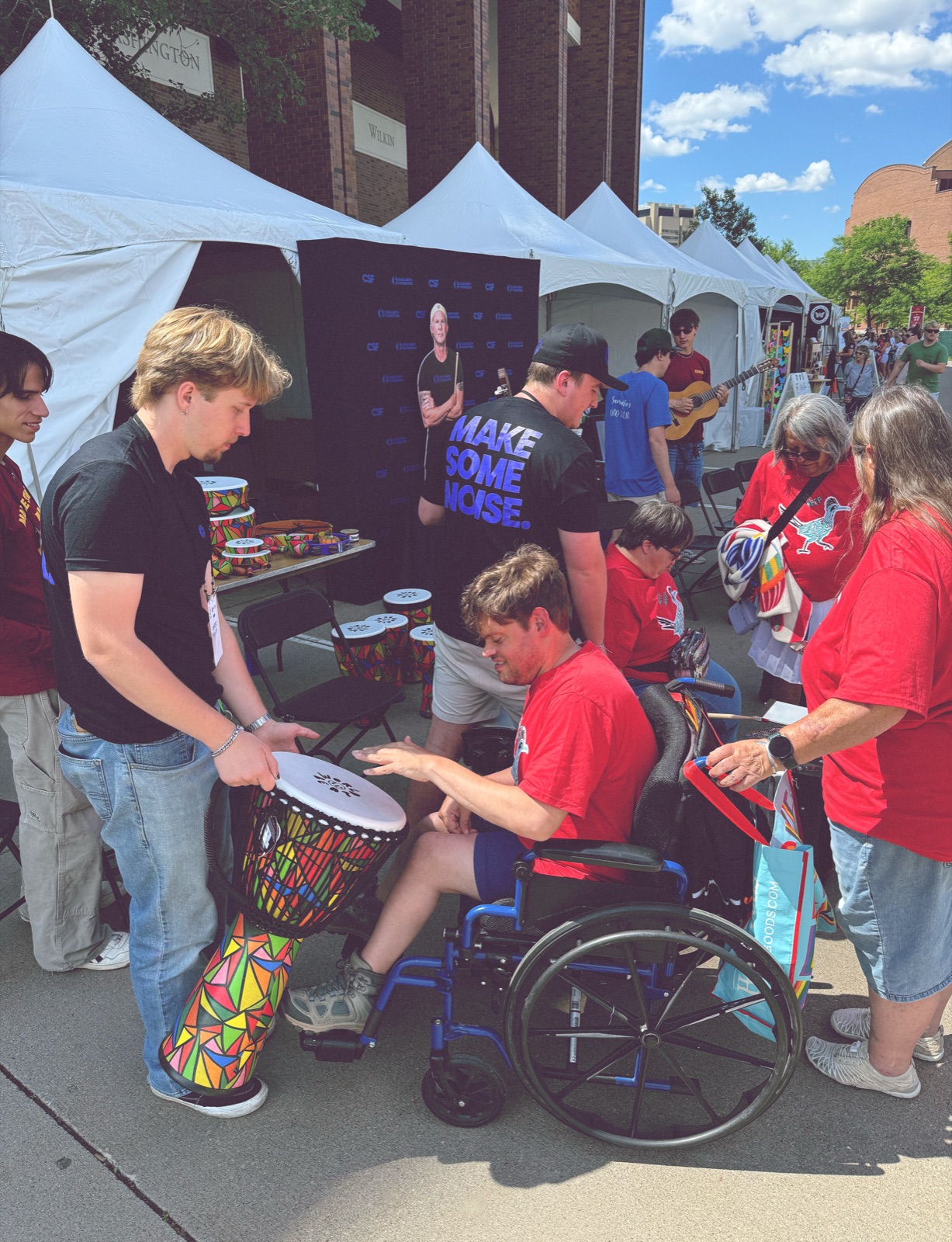 Participant raising a guitar at the Special Olympics music activation